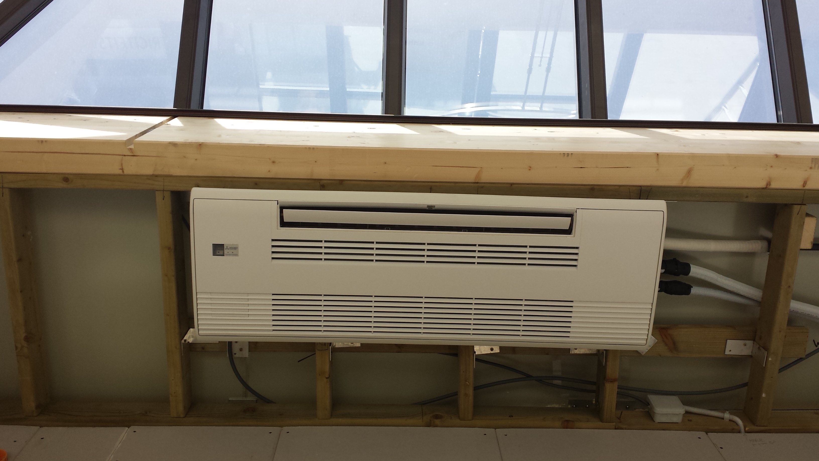 Witte Mitsubishi eenweg cassette-unit ingebouwd in een veranda.