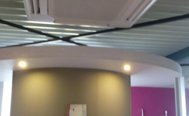 Mitsubishi buitenunit op een grindplatdak van een showroom.