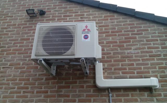 Witte Mitsubishi buitenunit op een bakstenen gevel te Sint-Lambrecht-Herk.